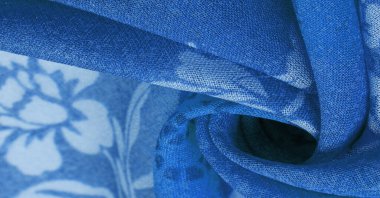 Green silk fabric with floral print. Clothing design. Modern floral background. Modern exotic jungle plants. Tinting, sunlight effect. Texture, background, design.