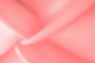 red pink silk fabric. a fine, strong, soft, lustrous fiber produced by silkworms in making cocoons and collected to make thread and fabric. Texture. Background.