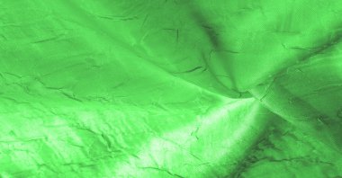 İpek kumaş yeşildir. Çizgilerle çizilmiş ve pürüzsüz. Doku arka planı. Matte düğün saten kumaşı. Bu sofistike hafif saten tekstil şık bir görünüm yaratır..