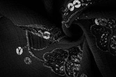 İpek siyahı. Kumaş pullarla süslenmiş. arka plan, ipek saten, lüks kumaş, koyu kumaş, kostüm pamuğu, soyut renk kalıbı, hassas sıvı kömür kadife.