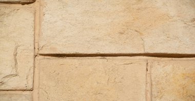 Binanın ön cephesinde kumtaşı taşları. Tortul kumtaşı. Genellikle inşaat malzemesi olarak ya da üretim için hammadde olarak çıkarılır. Metin, arkaplan, kalıp