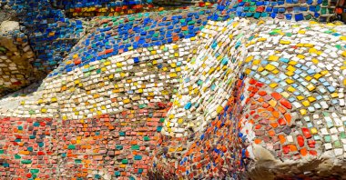 Eski mozaik. Beton bir yüzeyde çok renkli cam parçaları. Taş, kiremit ya da cam gibi sert bir maddenin küçük renkli parçalarını birleştirerek elde edilen bir desen..