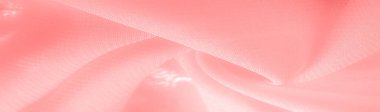 red pink silk fabric. a fine, strong, soft, lustrous fiber produced by silkworms in making cocoons and collected to make thread and fabric. Texture. Background.