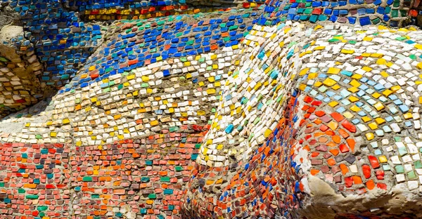 Eski mozaik. Beton bir yüzeyde çok renkli cam parçaları. Taş, kiremit ya da cam gibi sert bir maddenin küçük renkli parçalarını birleştirerek elde edilen bir desen..