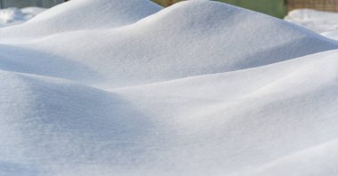 Snow texture atmospheric water vapor frozen into ice crystals and falling in light white flakes or lying on the ground as a white layer.