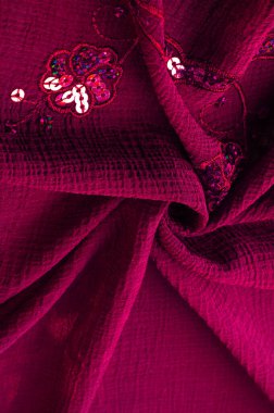 Silk red. The fabric is embellished with sequins. background, silk satin, luxurious texture, dark fabric, costume cotton material, abstract color image pattern, delicate liquid emerald velvet