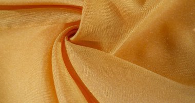 Sarı renkli ipek kumaş. Renkli ipek kumaşın dokusu arka plan olarak kullanılabilir