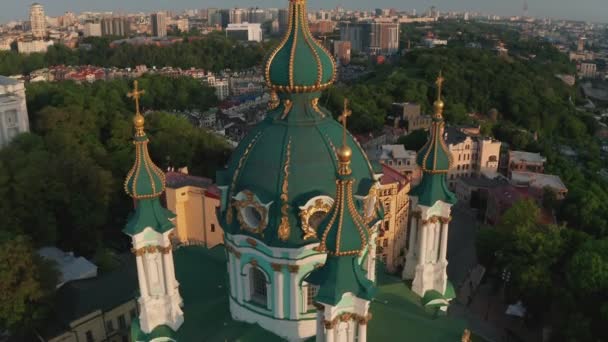 Luchtfoto van St. Andrews kerk bij zonsopgang, historisch centrum, Podolsk district, Kiev, Oekraïne. Een drone met een camera vliegt vanuit de kerk van St. Andrew. Vlieg rond St. Andrews kerk in Kiev. — Stockvideo