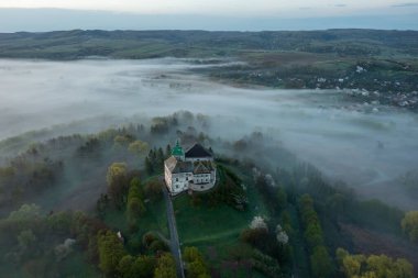 Olesko kalesinin havadan görünüşü. Sisli karanlık havada çok güzel bir kale. Lviv bölgesi, Ukrayna. Turizm, seyahat.