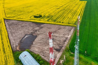 Aerial view video of telecommunication tower, in the countryside farming fields with 4G, 5G cellular network antennas.