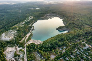 Göl ve şafak vakti yeşil ormanlarla çevrili güzel mavi turkuaz suyu olan sahil. Bir İHA 'dan havadan fotoğraf. Ukrayna. konsept, tatil, seyahat, doğa ve manzara
