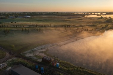Şafak vakti sisli bir sabah çiçek yataklarıyla dolu bir parkta büyüleyici, güzel, gölgeli bir manzara yaratır. Kavram, orman, çayır, alan, meditasyon, dinlenme, rahatlama. Hava görünümü