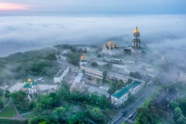 Şafak vakti Kiev-Pechersk Lavra 'nın yoğun sisle kaplı hava manzarası. Kiev, Ukrayna