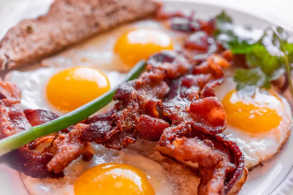 Tasty fried eggs eggs, and crispy bacon, close-up, great classic breakfast. Macro photography, shallow depth of field.