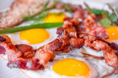 Lezzetli sahanda yumurta, ve kıtır pastırma, yakın plan, harika klasik kahvaltı. Makro fotoğrafçılık, alanın sığ derinliği.