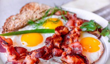 Lezzetli sahanda yumurta, ve kıtır pastırma, yakın plan, harika klasik kahvaltı. Makro fotoğrafçılık, alanın sığ derinliği.