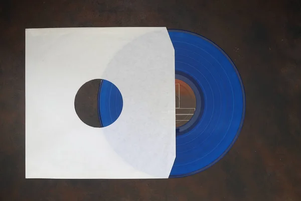 Weißer Papiereinband Und Blaue Schallplatte Isoliert Auf Rostigem Hintergrund — Stockfoto