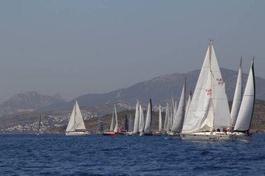 Bodrum, Türkiye. 14 Nisan 2018: Ünlü tatil beldesi Bodrum 'un kıyılarında, Ege Denizi' nin mavi sularında rüzgarlı havada yelken açan yelkenliler.