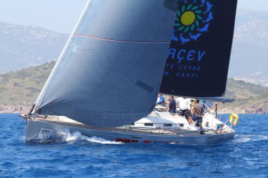 Bodrum, Türkiye. 14 Nisan 2018: Ünlü tatil beldesi Bodrum 'un kıyılarında, Ege Denizi' nin mavi sularında rüzgarlı havada yelken açan yelkenliler.