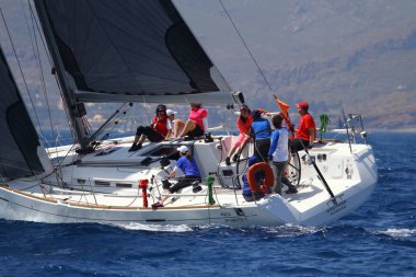 Bodrum, Türkiye. 14 Nisan 2018: Ünlü tatil beldesi Bodrum 'un kıyılarında, Ege Denizi' nin mavi sularında rüzgarlı havada yelken açan yelkenliler.