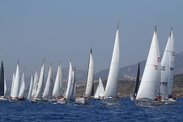 Bodrum, Türkiye. 14 Nisan 2018: Ünlü tatil beldesi Bodrum 'un kıyılarında, Ege Denizi' nin mavi sularında rüzgarlı havada yelken açan yelkenliler.