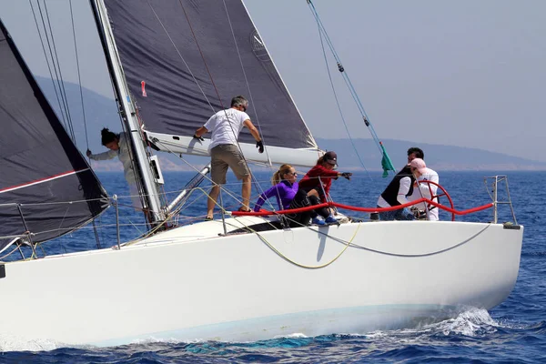 Bodrum, Türkiye. 14 Nisan 2018: Ünlü tatil beldesi Bodrum 'un kıyılarında, Ege Denizi' nin mavi sularında rüzgarlı havada yelken açan yelkenliler.
