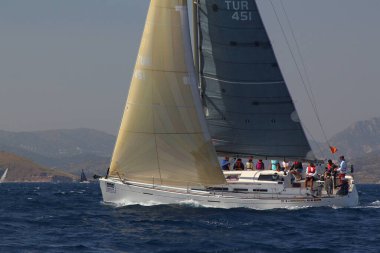 Bodrum, Türkiye. 14 Nisan 2018: Ünlü tatil beldesi Bodrum 'un kıyılarında, Ege Denizi' nin mavi sularında rüzgarlı havada yelken açan yelkenliler.