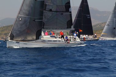 Bodrum, Türkiye. 14 Nisan 2018: Ünlü tatil beldesi Bodrum 'un kıyılarında, Ege Denizi' nin mavi sularında rüzgarlı havada yelken açan yelkenliler.