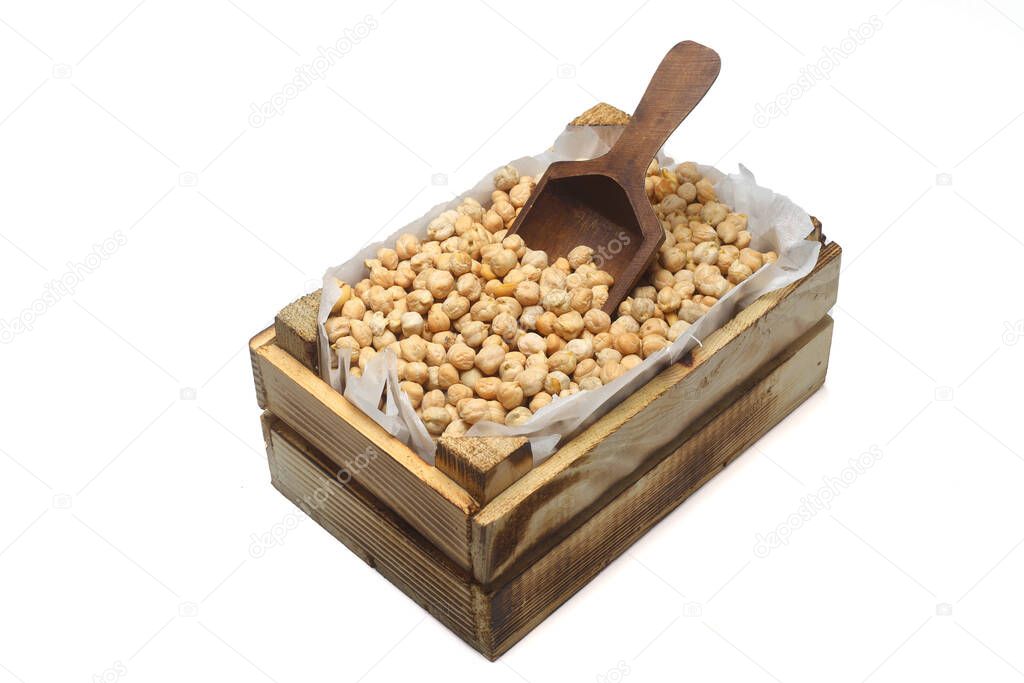 chickpeas in a small wooden crate, isolated on white background. With Wooden Spoon.