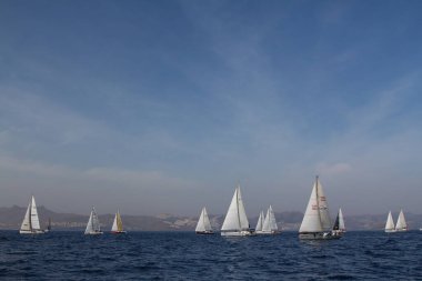Bodrum, Türkiye. 15 Nisan 2018: Ünlü tatil beldesi Bodrum 'un kıyılarında, Ege Denizi' nin mavi sularında rüzgarlı havada yelken açan yelkenliler.