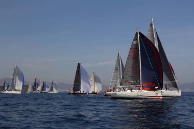 Bodrum, Türkiye. 15 Nisan 2018: Ünlü tatil beldesi Bodrum 'un kıyılarında, Ege Denizi' nin mavi sularında rüzgarlı havada yelken açan yelkenliler.