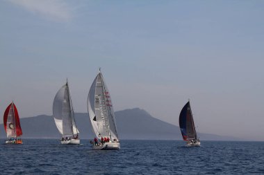 Bodrum, Türkiye. 15 Nisan 2018: Ünlü tatil beldesi Bodrum 'un kıyılarında, Ege Denizi' nin mavi sularında rüzgarlı havada yelken açan yelkenliler.