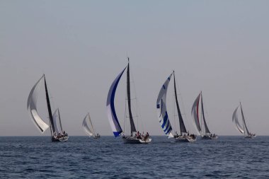 Bodrum, Türkiye. 15 Nisan 2018: Ünlü tatil beldesi Bodrum 'un kıyılarında, Ege Denizi' nin mavi sularında rüzgarlı havada yelken açan yelkenliler.