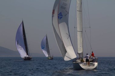 Bodrum, Türkiye. 15 Nisan 2018: Ünlü tatil beldesi Bodrum 'un kıyılarında, Ege Denizi' nin mavi sularında rüzgarlı havada yelken açan yelkenliler.