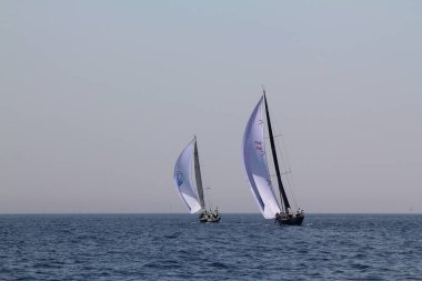 Bodrum, Türkiye. 15 Nisan 2018: Ünlü tatil beldesi Bodrum 'un kıyılarında, Ege Denizi' nin mavi sularında rüzgarlı havada yelken açan yelkenliler.