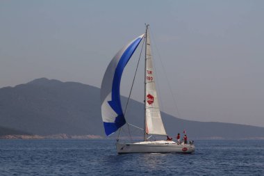 Bodrum, Türkiye. 15 Nisan 2018: Ünlü tatil beldesi Bodrum 'un kıyılarında, Ege Denizi' nin mavi sularında rüzgarlı havada yelken açan yelkenliler.