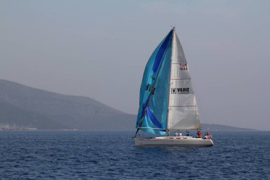 Bodrum, Türkiye. 15 Nisan 2018: Ünlü tatil beldesi Bodrum 'un kıyılarında, Ege Denizi' nin mavi sularında rüzgarlı havada yelken açan yelkenliler.