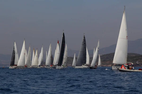 Bodrum, Türkiye. 15 Nisan 2018: Ünlü tatil beldesi Bodrum 'un kıyılarında, Ege Denizi' nin mavi sularında rüzgarlı havada yelken açan yelkenliler.