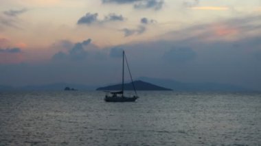 Günbatımında yalnız yelkenli. Atmosferik deniz manzarası