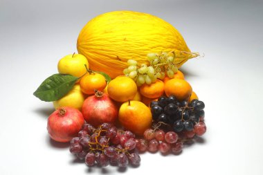 beyaz zemin üzerinde karpuz, elma, armut, nar, üzüm ve mandalina.