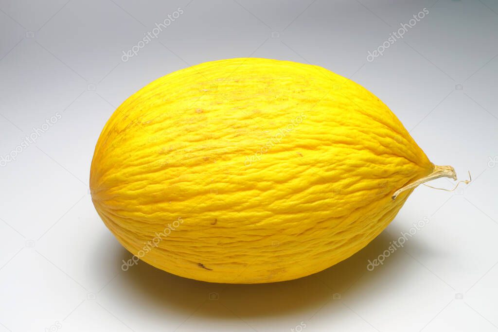 Melon on a white background. Yellow melon on a white isolate. For insertion into a project, design or advertisement.