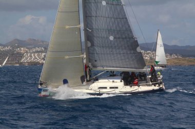 Bodrum, Hindi. 24 Mart 2018: Ege Denizi 'nin mavi sularında, ünlü tatil beldesi Bodrum' un kıyılarında yelkenliler rüzgarlı havada yelken açıyor.