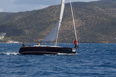Bodrum, Hindi. 24 Mart 2018: Ege Denizi 'nin mavi sularında, ünlü tatil beldesi Bodrum' un kıyılarında yelkenliler rüzgarlı havada yelken açıyor.