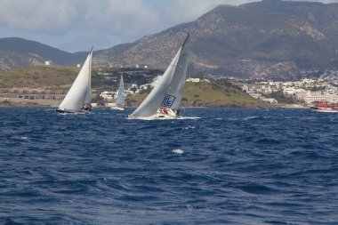 Bodrum, Hindi. 24 Mart 2018: Ege Denizi 'nin mavi sularında, ünlü tatil beldesi Bodrum' un kıyılarında yelkenliler rüzgarlı havada yelken açıyor.