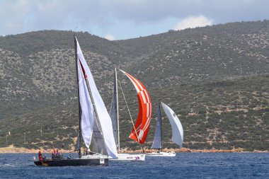 Bodrum, Hindi. 24 Mart 2018: Ege Denizi 'nin mavi sularında, ünlü tatil beldesi Bodrum' un kıyılarında yelkenliler rüzgarlı havada yelken açıyor.