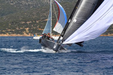Bodrum, Hindi. 24 Mart 2018: Ege Denizi 'nin mavi sularında, ünlü tatil beldesi Bodrum' un kıyılarında yelkenliler rüzgarlı havada yelken açıyor.