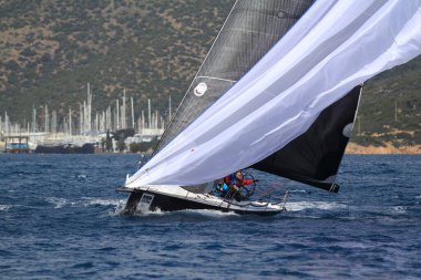 Bodrum, Hindi. 24 Mart 2018: Ege Denizi 'nin mavi sularında, ünlü tatil beldesi Bodrum' un kıyılarında yelkenliler rüzgarlı havada yelken açıyor.