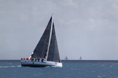 Bodrum, Hindi. 24 Mart 2018: Ege Denizi 'nin mavi sularında, ünlü tatil beldesi Bodrum' un kıyılarında yelkenliler rüzgarlı havada yelken açıyor.