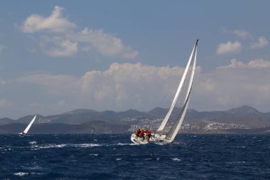 Bodrum, Hindi. 24 Mart 2018: Ege Denizi 'nin mavi sularında, ünlü tatil beldesi Bodrum' un kıyılarında yelkenliler rüzgarlı havada yelken açıyor.