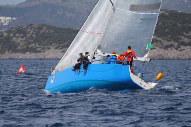 Bodrum, Hindi. 25 Mart 2018: Yelkenliler Ege Denizi 'nin mavi sularında, ünlü tatil beldesi Bodrum' un kıyılarında rüzgarlı havada yelken açıyor..